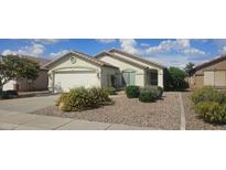 Charming single-story home with a well-manicured yard, desert landscaping, and a two-car garage at 14767 N 148Th Ave, Surprise, AZ 85379