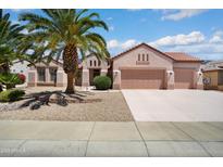 Charming single-story home featuring a three-car garage, mature palm trees, and low-maintenance desert landscaping at 16158 W Copper Point Ln, Surprise, AZ 85374