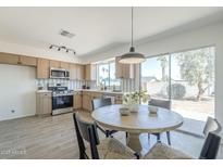 Bright kitchen with stainless steel appliances and a cozy dining area with sliding glass doors to outdoor space at 1708 W Estrella Dr, Chandler, AZ 85224