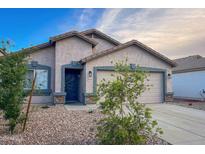 Charming single-story home featuring a well-maintained front yard with gravel and a two-car garage at 22755 W Yavapai St, Buckeye, AZ 85326