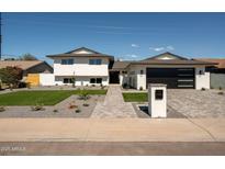Beautiful two-story home featuring a manicured lawn and stylish gray brick walkway, creating a welcoming entrance at 3413 N 87Th Pl, Scottsdale, AZ 85251