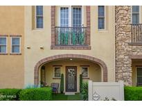 Charming home entrance featuring an arched doorway, decorative door, manicured greenery, and a quaint seating area at 4419 N 24Th Way, Phoenix, AZ 85016
