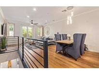 Open concept living and dining area with modern lighting, wood floors, and large windows at 4419 N 24Th Way, Phoenix, AZ 85016