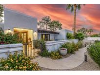 Charming courtyard entrance with wrought iron gate and lush desert landscaping at 6112 E Jenan Dr, Scottsdale, AZ 85254