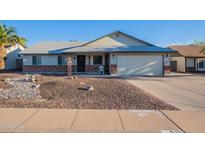 Charming single-story home featuring desert landscaping, a two-car garage, and a welcoming front porch at 6311 E Ivy St, Mesa, AZ 85205