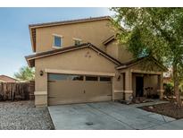 Charming two-story home featuring a well-maintained front yard with a two car garage at 7090 S 252 Dr, Buckeye, AZ 85326