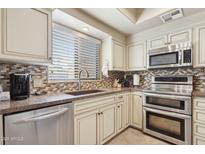 Updated kitchen with stainless steel appliances, tile backsplash, and a window for natural light at 7575 E Indian Bend Rd # 1137, Scottsdale, AZ 85250