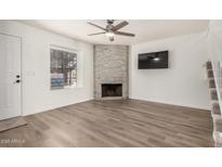 Inviting living room showcasing a stone fireplace, wood floors, and a contemporary ceiling fan at 921 W University Dr # 1038, Mesa, AZ 85201