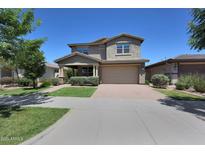 Charming two-story home featuring a neutral color palette, manicured front yard, and a welcoming two-car garage at 9750 E Radioactive Dr, Mesa, AZ 85212