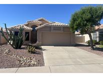 Charming single-story home with desert landscaping, a two-car garage, and a neutral color palette at 9853 W Pontiac Dr, Peoria, AZ 85382