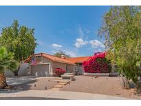 Inviting one-story home with a lush garden, desert landscaping, and a two-car garage at 10580 E Bella Vista Dr, Scottsdale, AZ 85258