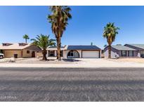 Charming single-story home with solar panels and desert landscaping, including palm trees at 10610 W Diana Ave, Peoria, AZ 85345