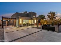 Stunning modern home featuring a sleek design, a spacious driveway, and an inviting outdoor seating area at 1211 E Hayward Ave, Phoenix, AZ 85020