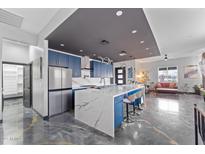 Open kitchen with a large center island, modern lighting, and stainless steel refrigerator at 1211 E Hayward Ave, Phoenix, AZ 85020