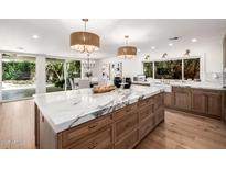Beautiful kitchen island with white marble countertop and wooden drawers, perfect for food preparation at 16227 N 63Rd Pl, Scottsdale, AZ 85254