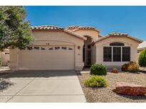 Charming single-story home featuring a two-car garage and desert landscaping at 20424 N 96Th Ln, Peoria, AZ 85382