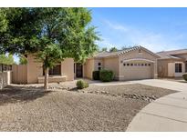 Charming single-story home showcasing desert landscaping, a spacious driveway, and a two-car garage at 21299 E Roundup Way, Queen Creek, AZ 85142