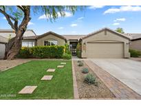Charming single-story home with well-maintained landscaping, stone pathway, and attached two-car garage at 26264 N 46Th St, Phoenix, AZ 85050