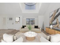 Bright living room features a skylight, modern chandelier, and neutral decor for a cozy and stylish atmosphere at 2712 W Oakgrove Ln, Chandler, AZ 85224