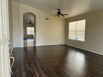 Bright living room featuring dark wood floors, ceiling fan, and archway to another room at 3633 E Potter Dr, Phoenix, AZ 85050