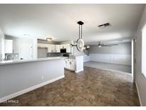 Open concept living room and kitchen with tile flooring and natural light at 37061 W Bello Ln, Maricopa, AZ 85138