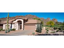 Charming single-story home featuring desert landscaping, a two-car garage, and a backdrop of beautiful mountain views at 5023 S Dusty Coyote Trl, Gold Canyon, AZ 85118