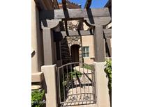 Charming front entrance features a stone archway, pergola, and decorative metal gate at 6202 E Mckellips Rd # 25, Mesa, AZ 85215