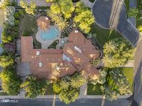 Stunning aerial view of a large property featuring a pool, lush landscaping, and a unique tile roof design at 8815 N 65Th St, Paradise Valley, AZ 85253