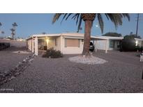 Single-story home boasting a covered parking, complemented by rock landscaping, and palm trees at 103 S 75Th Pl, Mesa, AZ 85208