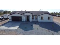 New construction with neutral colored stucco, gray roof, modern garage door, and low maintenance rock yard at 11798 S 216Th Ave, Buckeye, AZ 85326