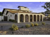 Charming home featuring arched entryways, private gates, desert landscaping, and paved driveway at 1249 E Desert Park Ln, Phoenix, AZ 85020