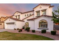 Charming two-story home featuring a well-maintained lawn, arched entryway, and a three-car garage at 1429 E Lowell Ave, Gilbert, AZ 85295