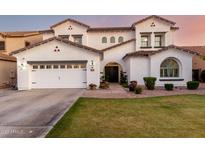 Charming two-story home featuring a well-maintained lawn, arched entryway, and a three-car garage at 1429 E Lowell Ave, Gilbert, AZ 85295