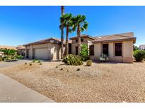 Beautiful single story home with desert landscaping and mature palm trees enhancing the curb appeal at 15801 W Goldenrod Dr, Surprise, AZ 85374