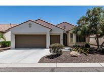 Charming single-story home with a desert landscape, a three-car garage, and a warm, inviting facade at 16747 W Berkeley Rd, Goodyear, AZ 85395