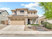 Two-story home featuring a tile roof, neutral stucco exterior, and a two-car garage with solar panels on the roof at 21054 N Sansom Dr, Maricopa, AZ 85138