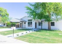 Beautifully renovated home with a well-manicured lawn, modern white paint, and stylish black accents at 214 W Ruth Ave, Phoenix, AZ 85021