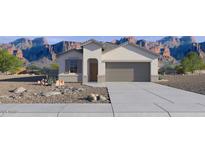 Charming single-story home featuring neutral stucco, a two-car garage and desert landscaping, set against a mountain backdrop at 22570 N Lynn St, Maricopa, AZ 85138