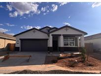 Charming single-story home featuring a gray color scheme, a two-car garage, and drought-resistant landscaping at 22610 N Lynn St, Maricopa, AZ 85138
