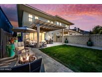 A backyard features an outdoor dining set, a fire pit, patio furniture, and a green lawn at 306 W Culver St, Phoenix, AZ 85003