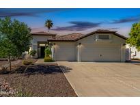 Charming home with a well-manicured front yard, spacious driveway and attached three-car garage at 4335 E Enrose St, Mesa, AZ 85205