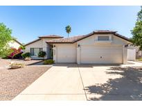 Charming home featuring a well-maintained lawn, two-car garage, and a warm, inviting facade at 4335 E Enrose St, Mesa, AZ 85205