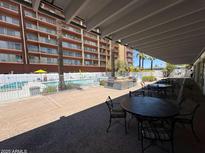 Outdoor patio with BBQ grills near a sparkling pool with lounge chairs and lush landscaping at 4750 N Central Ave # R3, Phoenix, AZ 85012