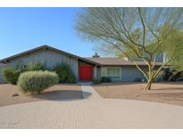 Charming single-story home featuring a red front door, desert landscaping, and a paved walkway at 6408 E Gary Rd, Scottsdale, AZ 85254