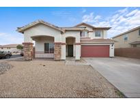 Charming two-story home with a red two-car garage, stone accents, and a covered front porch at 7309 W Getty Dr, Phoenix, AZ 85043