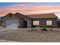 Charming single-story home featuring neutral tones, a two-car garage, and a well-maintained desert landscape at 10138 W Oregon Ave, Glendale, AZ 85307