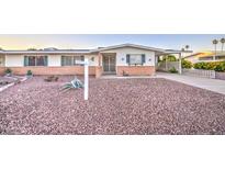 Charming single-story home with a low brick wall and desert landscaping featuring gravel and sparse vegetation at 10620 W Clair Dr, Sun City, AZ 85351