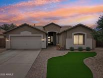 Charming single-story home featuring a well-manicured front yard and brick paved walkway at sunset at 1070 S Amber St, Chandler, AZ 85286