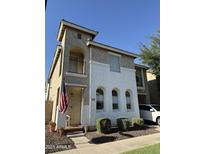 Charming two-story home featuring stucco siding, arched windows, and a welcoming entrance with an American flag at 1448 E Mobile Ln, Phoenix, AZ 85040