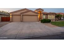 Inviting exterior view of a home with a three-car garage and well-manicured landscaping at dusk at 1506 W Laurel Ave, Gilbert, AZ 85233